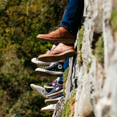 image of legs with sneakers dangling from a wall